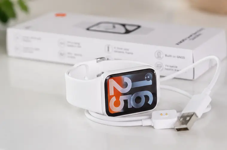 Белые смарт-часы Xiaomi с силиконовым ремешком на современном светлом фоне, комплект поставки и сменный ремешок.
